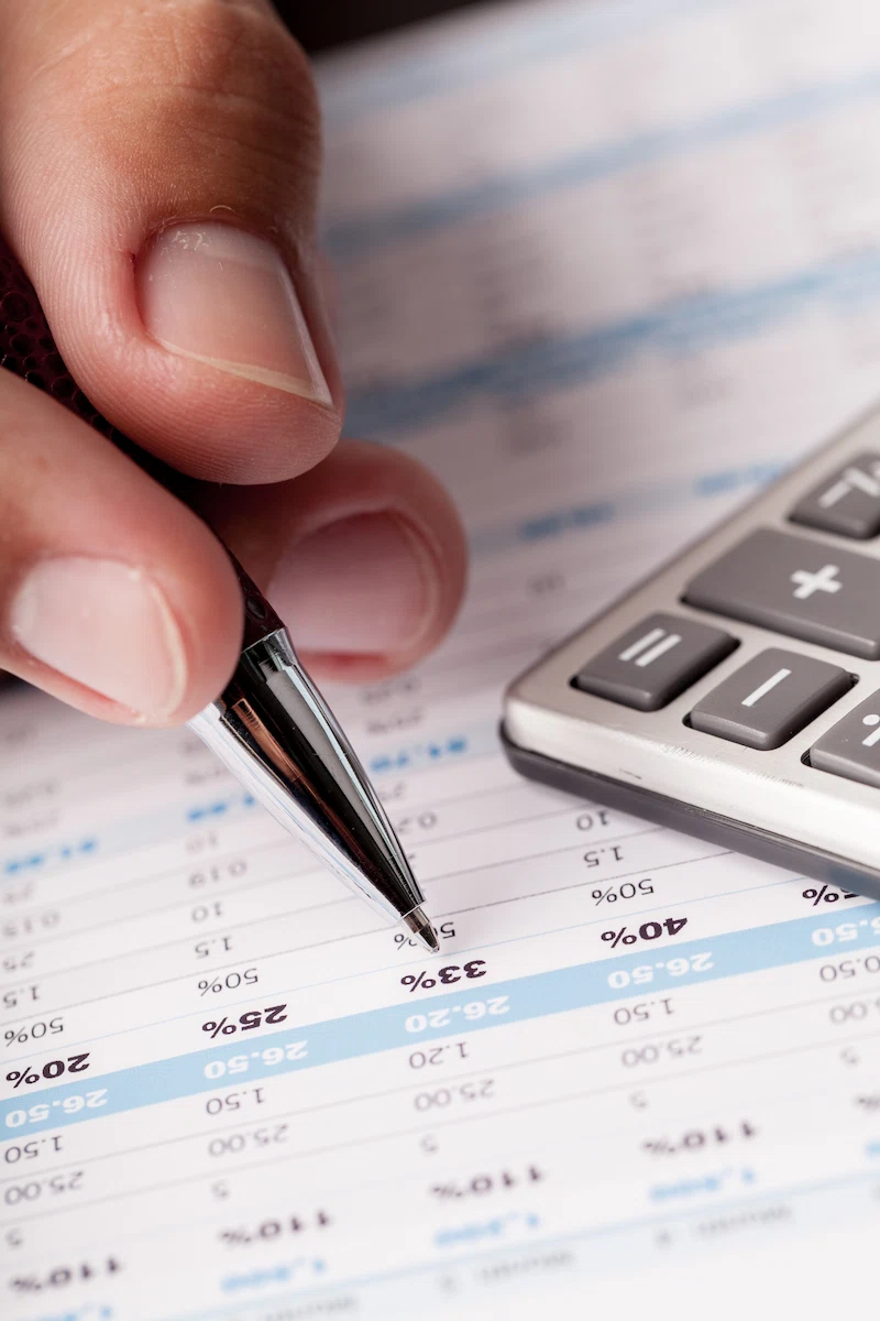 analisis de datos financieros foto de primer plano de la mano de un hombre de negocios contando con la calculadora en la oficina - GSG Consultores